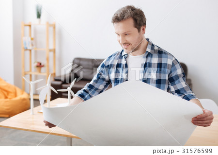 Positive delighted bearded man holding big paper 31576599