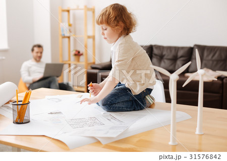 Funny kid sitting on his legs on the table 31576842