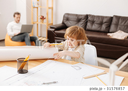 Positive delighted boy unrolling big sheet of Positive delighted boy unrolling big sheet of 31576857