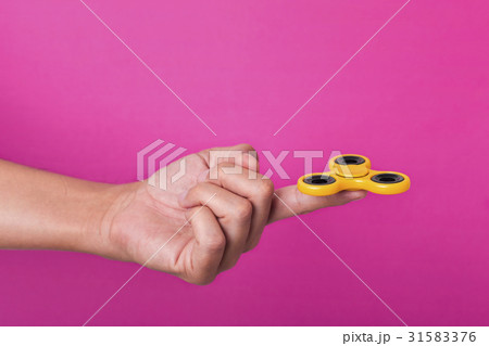 young man playing with a fidget spinner 31583376