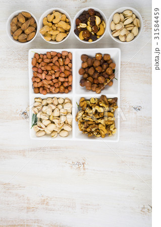 Bowls with nuts on a  wooden table 31584459