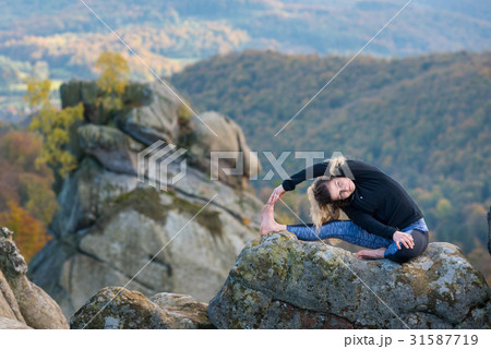 Woman practicing yoga on the top of the mountain 31587719