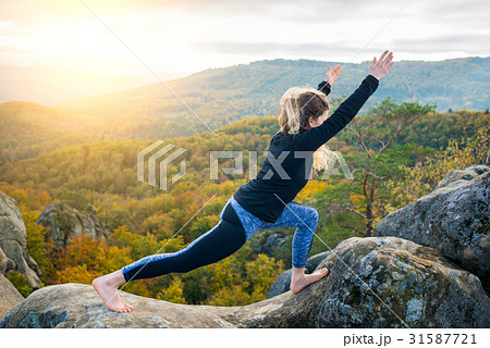 Woman practicing yoga on the top of the mountain Woman practicing yoga on the top of the mountain 31587721