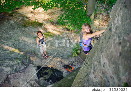 Female climber climbing with rope on a rocky wall Female climber climbing with rope on a rocky wall 31589025