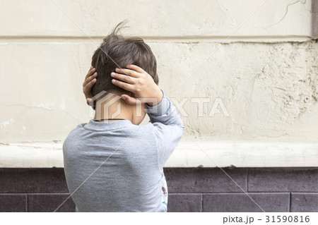 Young kid with closed ears 31590816