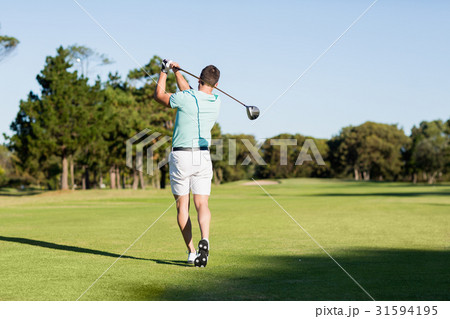 Rear view of young golfer man taking shot Rear view of young golfer man taking shot 31594195