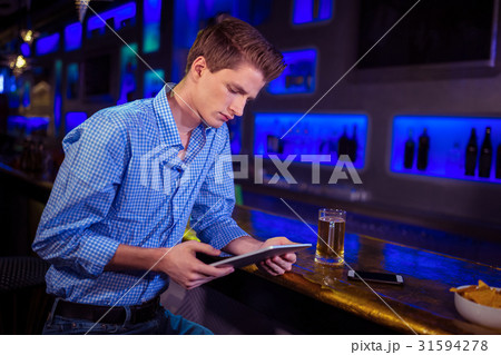 Young man using digital tablet at bar counter 31594278