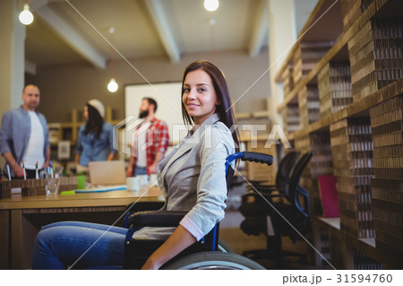 Businesswoman on wheelchair by desk 31594760