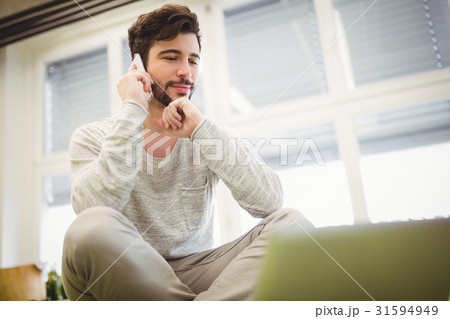 Businessman using mobile phone in office 31594949