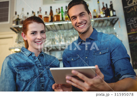 Portrait of cheerful baristas with digital tablet at cafe Portrait of cheerful baristas with digital tablet at cafe 31595078