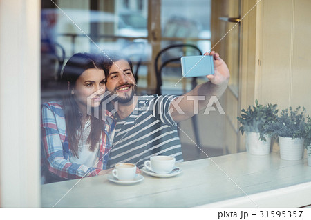 Couple taking selfie at cafe Couple taking selfie at cafe 31595357