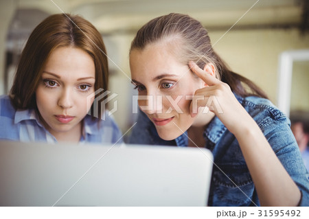 Close-up of businesswomen working on laptop in office Close-up of businesswomen working on laptop in office 31595492