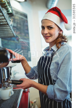 Portrait of waitress using coffee maker at cafeteria during Christmas Portrait of waitress using coffee maker at cafeteria during Christmas 31595505