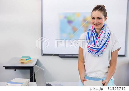 Portrait of teacher against whiteboard in classroom 31595712