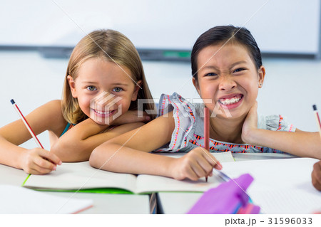 Smiling schoolgirls writing on books Smiling schoolgirls writing on books 31596033
