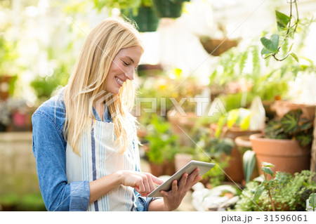 Female gardener using digital tablet at greenhouse 31596061