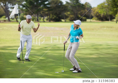 Mature golfer couple celebrating success Mature golfer couple celebrating success 31596383