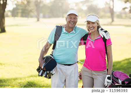 Happy mature golfer couple with arm around 31596393