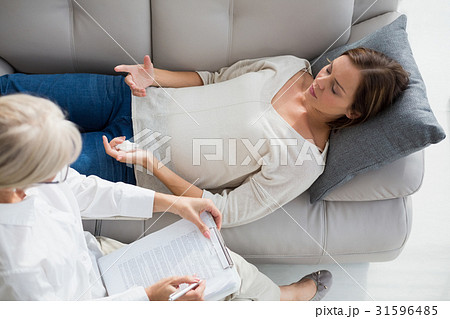 High angle view of woman lying on sofa by therapist 31596485