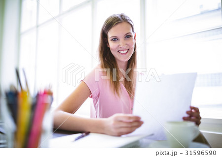 Graphic designer holding sheet of paper Graphic designer holding sheet of paper 31596590
