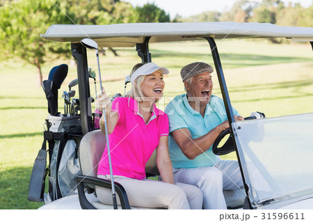 Mature couple sitting in golf buggy 31596611