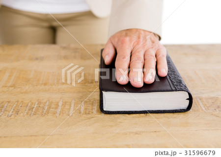 Midsection of woman with hand on bible Midsection of woman with hand on bible 31596679