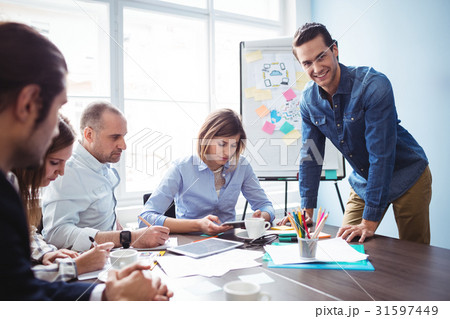Smiling businessman with coworkers in meeting room 31597449