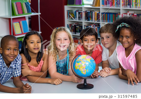 Smiling children with globe on table 31597485