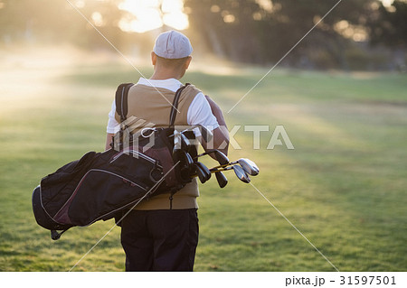Rear view of man carrying golf bag Rear view of man carrying golf bag 31597501