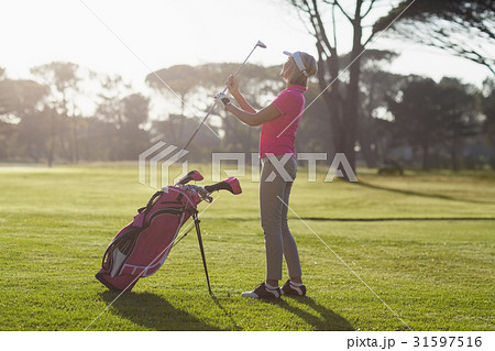 Full length of woman carrying golf club Full length of woman carrying golf club 31597516