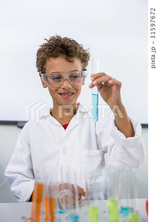 Boy holding test tube with liquid at laboratory 31597672