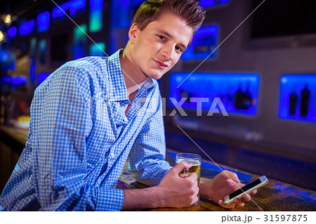 Portrait of man using mobile phone at bar counter 31597875