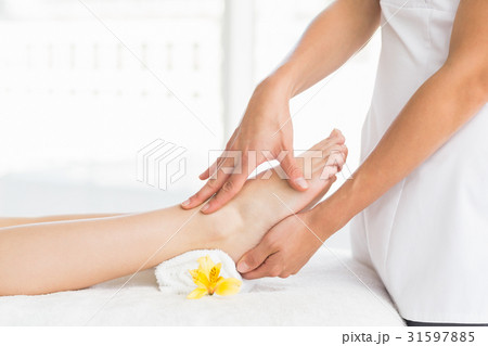 Midsection of masseur giving foot massage to woman Midsection of masseur giving foot massage to woman 31597885