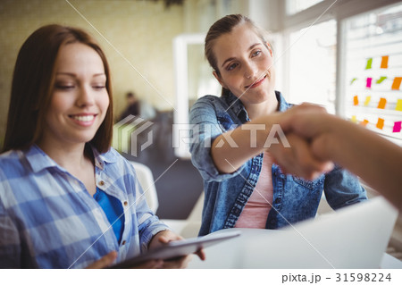 Happy businesswomen shaking hands in office 31598224