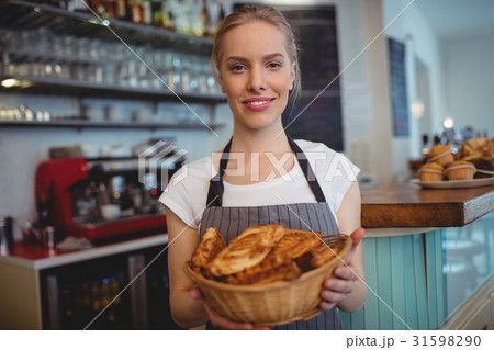 Portrait of confident waitress serving breads at coffee house 31598290