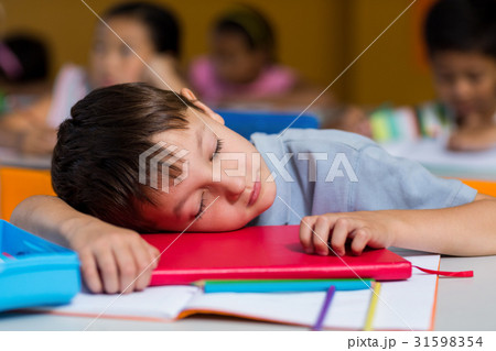 Cute boy sleeping on desk Cute boy sleeping on desk 31598354