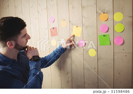 Man looking at sticky notes Man looking at sticky notes 31598486