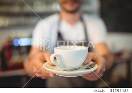 Close-up of barista serving coffee at cafeteria Close-up of barista serving coffee at cafeteria 31598488