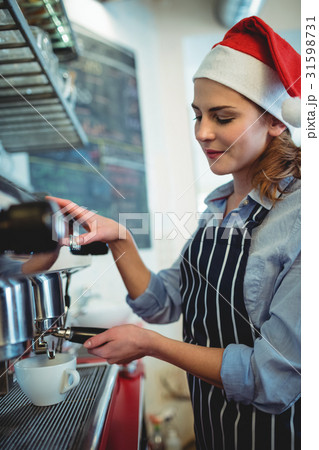 Waitress wearing Santa hat using espresso maker at cafe Waitress wearing Santa hat using espresso maker at cafe 31598731