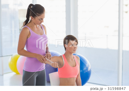 Trainer guiding woman 31598847