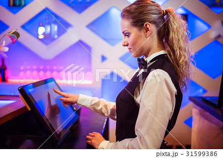 Barmaid using modern cash register at bar counter 31599386