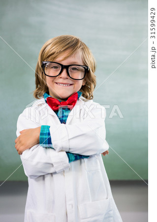 Smiling boy dressed as scientist standing in classroom Smiling boy dressed as scientist standing in classroom 31599429