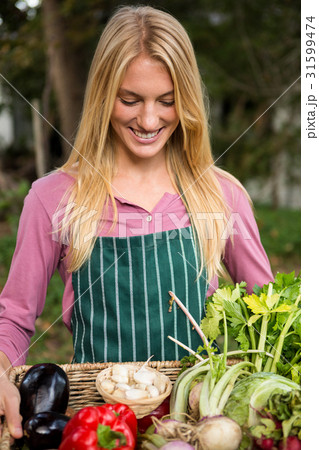 Happy gardener with fresh vegetables in basket at garden 31599474