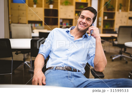 Smiling businessman talking on phone Smiling businessman talking on phone 31599533
