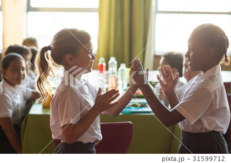 Smiling schoolgirls playing clapping game Smiling schoolgirls playing clapping game 31599712