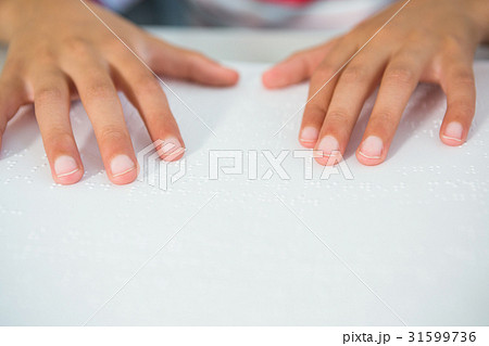 Cropped image of child reading braille book Cropped image of child reading braille book 31599736