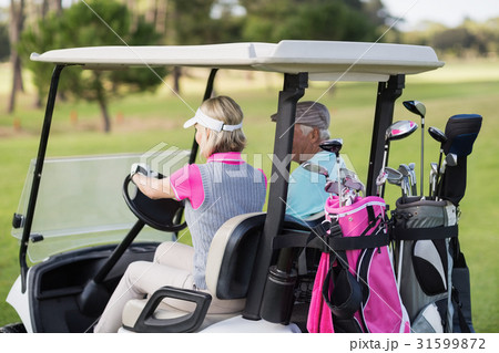 Mature woman driving golf buggy 31599872