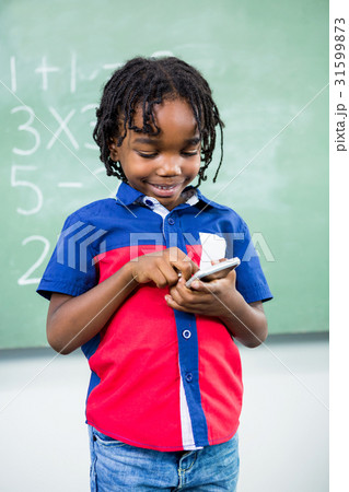 Boy using mobile phone in classroom Boy using mobile phone in classroom 31599873
