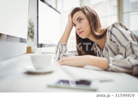 Businesswoman looking at computer in creative office 31599929