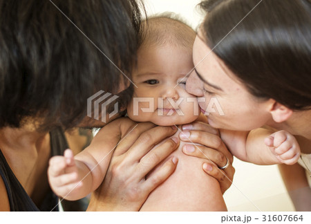 Father and mother are taking care of their child. 31607664